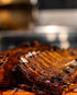 Close-up of Texas-style pork ribs with a browned crust and glossy barbecue glaze